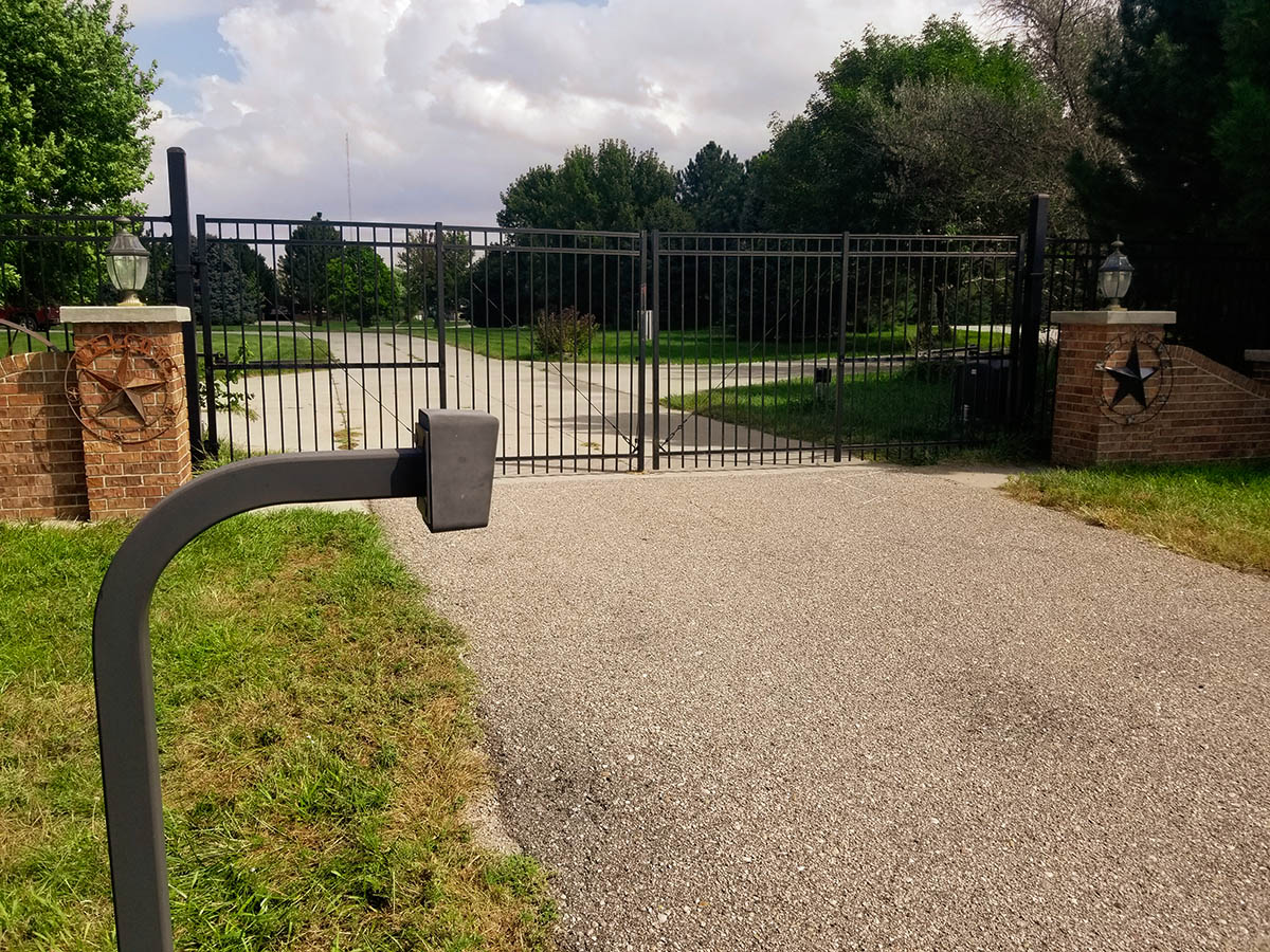 Black ornamental picket style double swing gate with access control pad. Grand Island fence company fence contractors Nebraska gates automation residential commercial